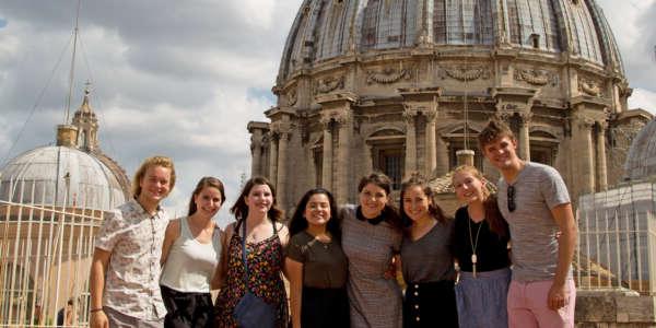 Students pose for a photo in front of a domed building while studying abroad